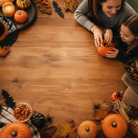 Family pumpkin carving overhead halloween table