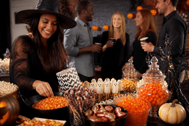 Woman witch hat serving candy halloween party